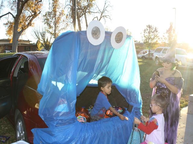 Child handing out candy in decorated trunk at El Centro's Trunk n Treat 2022