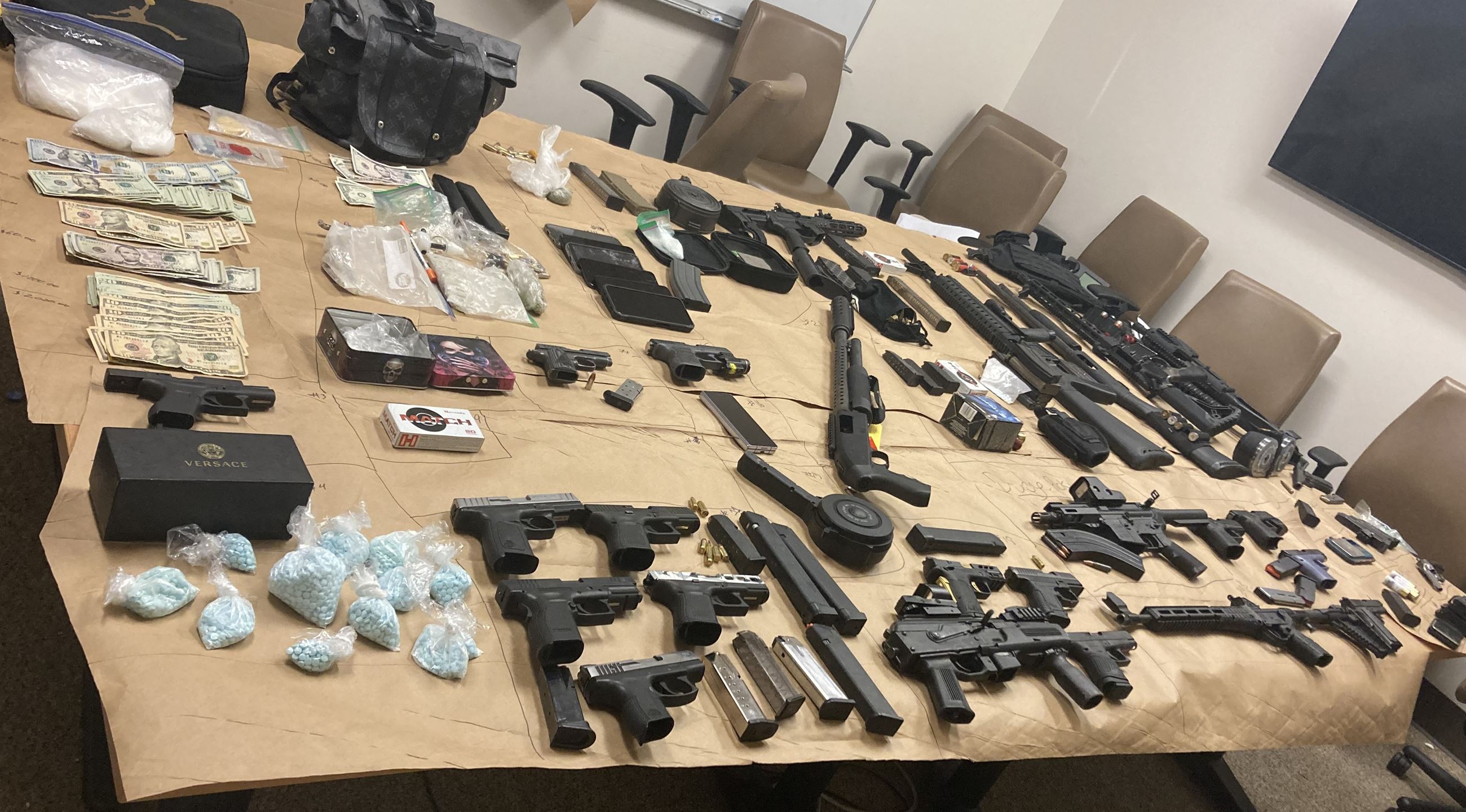 Photo of a large amount of guns, drugs and money.